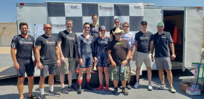 Group of volunteers wearing matching t-shirts in front of a trailer with K&F and Otterhaus branding.